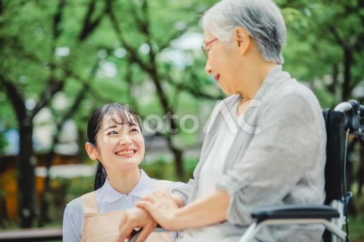 車椅子に乗った高齢者女性と女性スタッフ 介護士,介護福祉士,看護師の写真素材