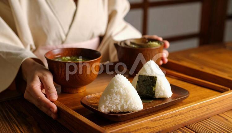 お盆に乗ったおにぎりと味噌汁を持つ女性 おにぎり,味噌汁,お盆の写真素材