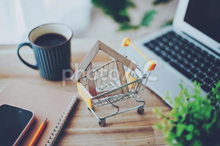 木製の家を積んだショッピングカート ショッピングカート,カート,買い物の写真素材