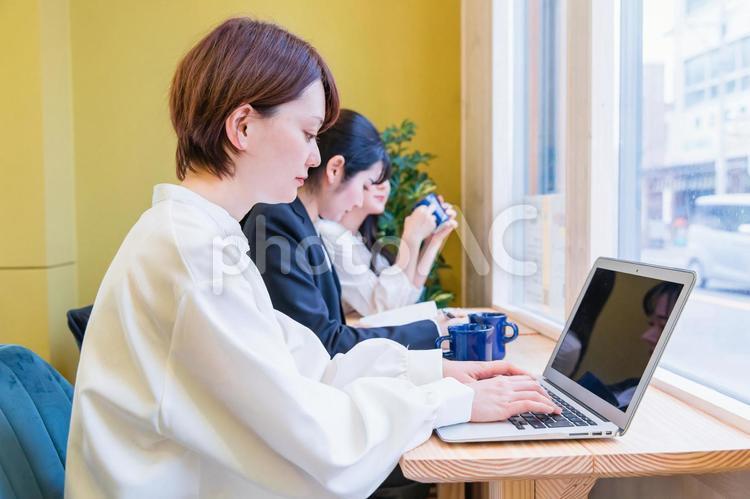 カフェでノートパソコンを使う若い女性 テレワーク,仕事,リモートワークの写真素材
