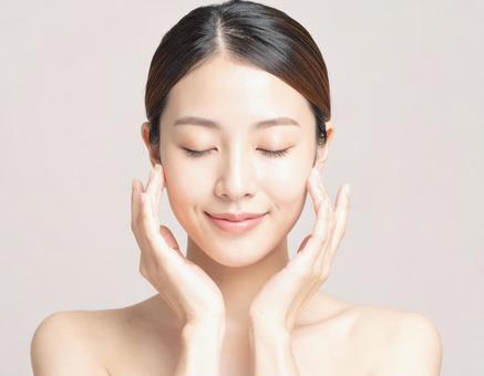 フェイスマッサージをする女性 フェイスマッサージをする女性の写真