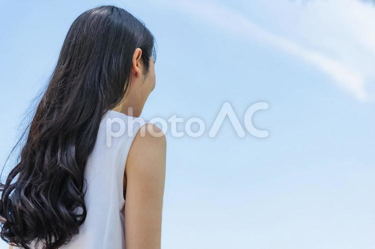 青空と後ろ姿の女性(黒髪・ロングヘアー） 青空,女性,雲の写真素材