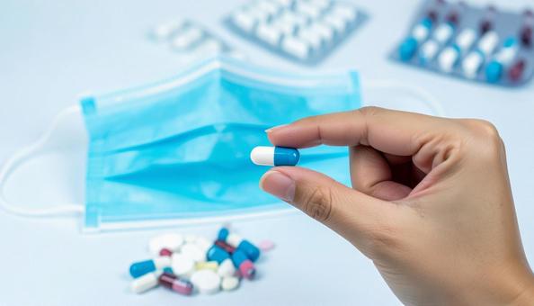 特効薬のイメージ 薬をつまむ女性の手 特効薬のイメージ 薬をつまむ女性の手の写真
