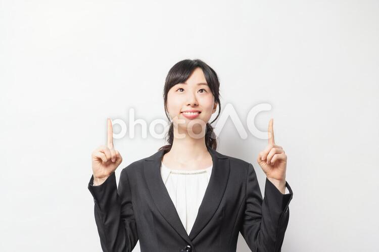 人差し指でポイントを指し示す若い女性 女性,笑顔,ビジネスの写真素材