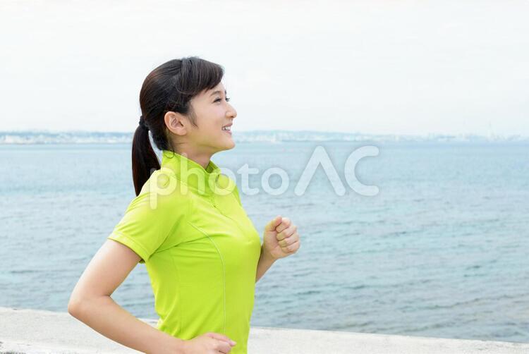 海岸でジョギングを楽しむ女性 沖縄,女性,女の写真素材