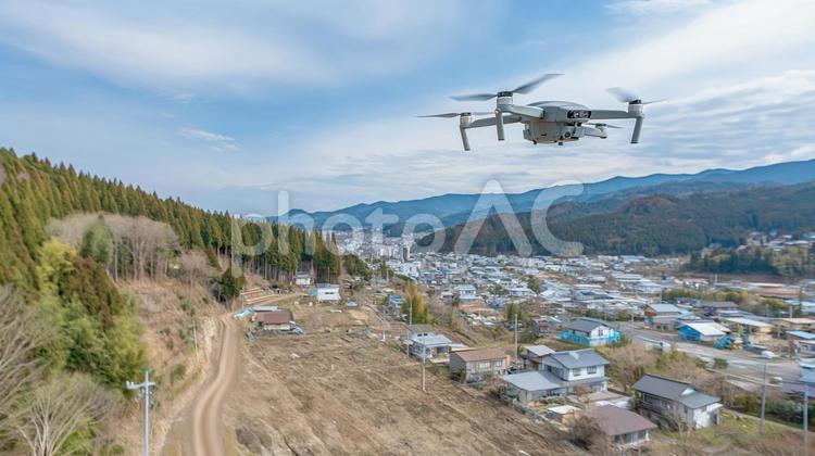 山あいの町を巡回する偵察ドローン ドローン,空撮,災害現場の写真素材