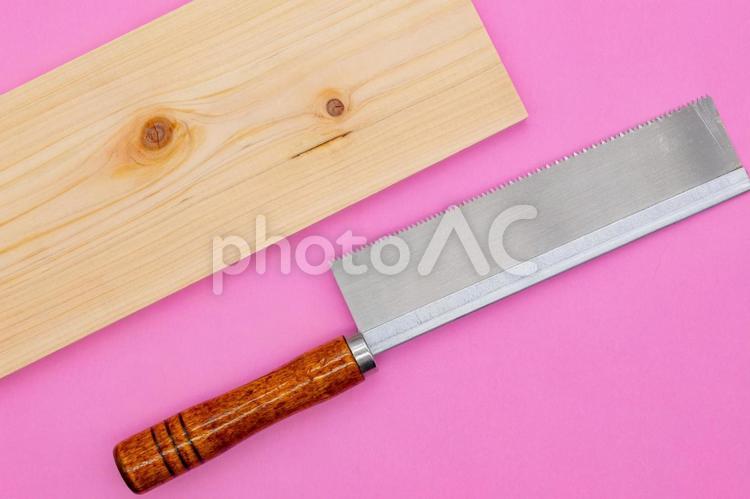 ピンク背景にのこぎりとヒノキの板 工具,道具,日曜大工の写真素材