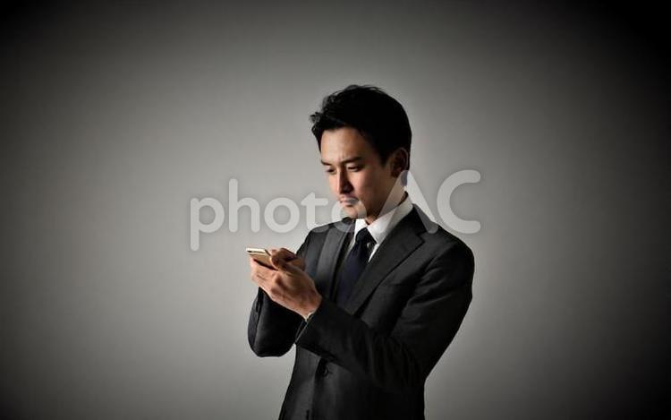 携帯を持つビジネスマン 男性,日本人,1人の写真素材