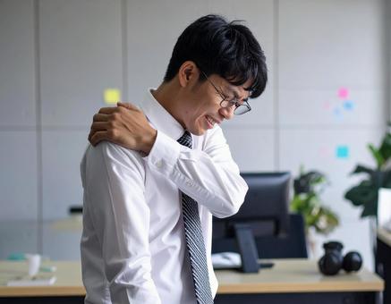 辛い肩凝りで苦しむ男性 辛い肩凝りで苦しむ男性の写真