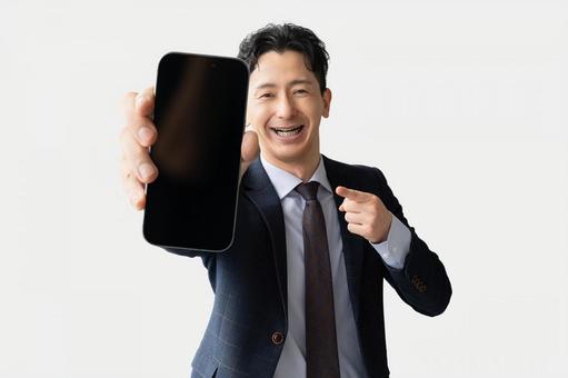 スマホの画面を見せる男性ビジネスマン スマホの画面を見せる男性ビジネスマン 男性,スマホ,スマートフォンの写真素材