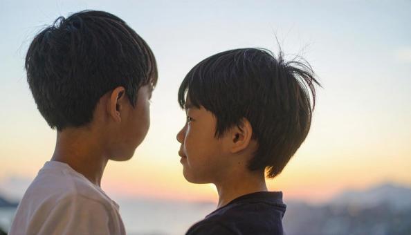 夕焼けの空を見つめる日本人の少年 夕焼けの空を見つめる日本人の少年の写真