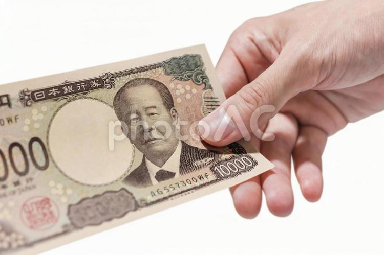 一万円札を1枚持っている手 新紙幣,一万円,受け取るの写真素材