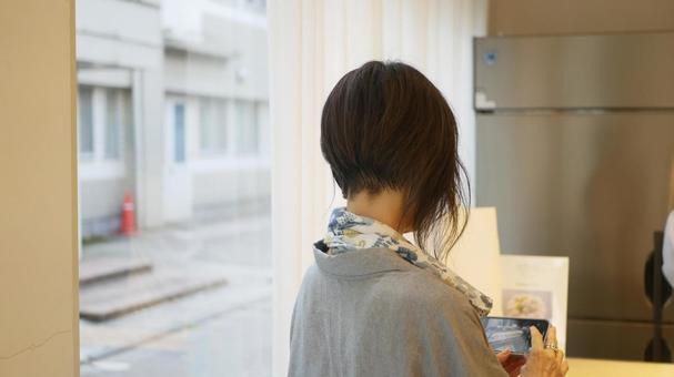 ショーケースを見て写真を撮る女性 ショーケースを見て写真を撮る女性の写真