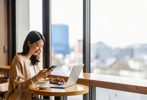 スマホとPCでSNSにAIで投稿する女子 スマホとPCでSNSにAIで投稿する女子の写真