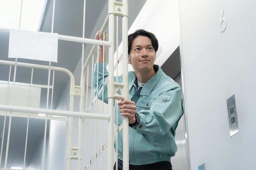 倉庫で荷物を運ぶ若い男性作業員 倉庫で荷物を運ぶ若い男性作業員 倉庫,工場,配達の写真素材