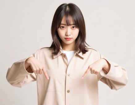 下を指差す女性 下を指差す女性の写真
