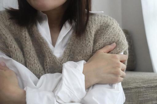 ニットベストを着た寒そうな女性 寒い,寒気,女性の写真素材