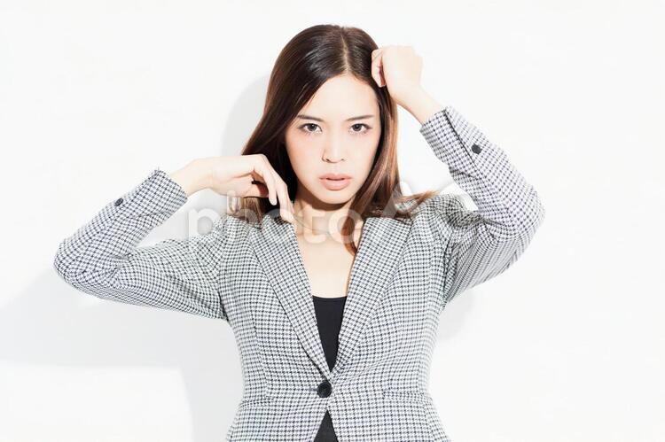 白い背景の前に立ってポーズをとる若いビジネスウーマン 女性,白背景,立つの写真素材