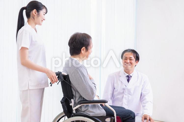 車椅子に乗る患者と医者（話す） 医者,介護士,車椅子の写真素材