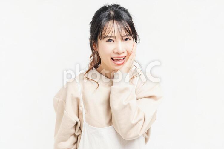 頬に手を当てる笑顔の若い女性 女性,頬,笑うの写真素材