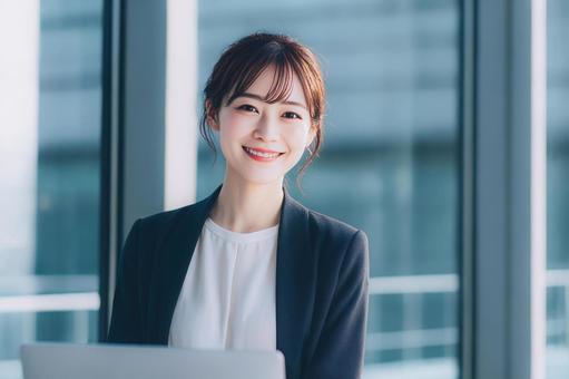 ノートパソコンを使用する女性会社員 ノートパソコンを使用する女性会社員の写真