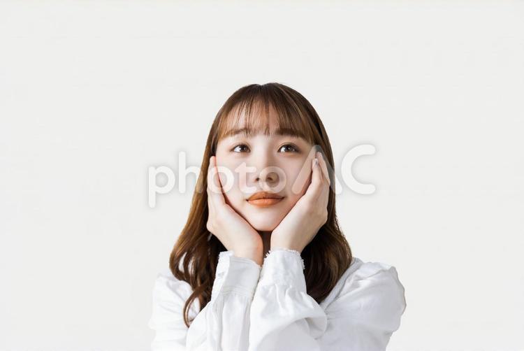両手で頬を押さえて考えるビジネスウーマン 女性,ビジネス,ビジネスウーマンの写真素材