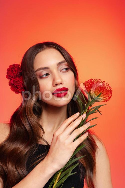 右手で花を持ち横目の女性 女性,ピンクッション,持つの写真素材