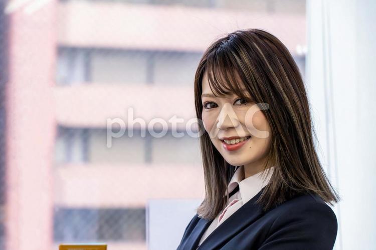 オフィスの窓際で笑顔の女性 女性,笑顔,笑うの写真素材