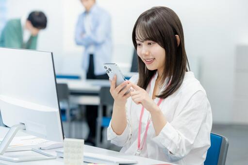 オフィスでスマホを持つビジネスウーマン スマホ,笑顔,ビジネスウーマンの写真素材