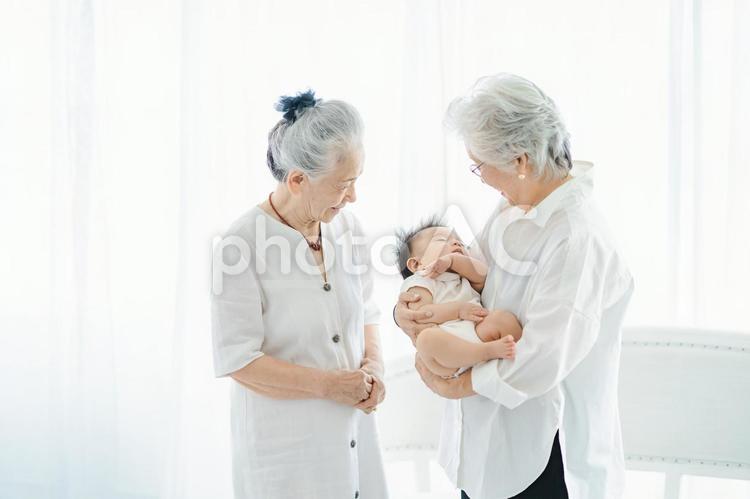 赤ちゃんを抱っこするシニア女性  孫,おばあちゃん,肌の写真素材