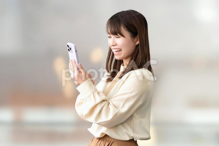 笑顔でスマホを使う女性・ビジネスウーマン 女性,笑顔,スマホの写真素材