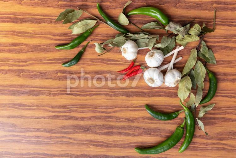 木目の机ニンニクや唐辛子など 青唐辛子,赤唐辛子,ニンニクの写真素材