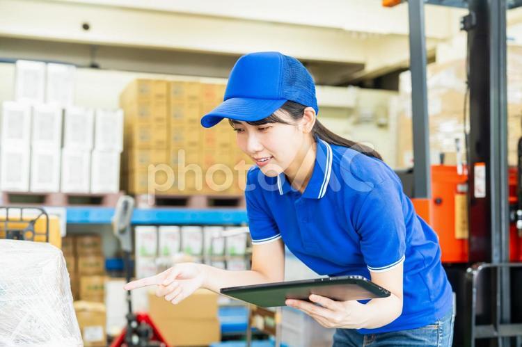 荷物を管理する若い女性 倉庫,工場,笑顔の写真素材