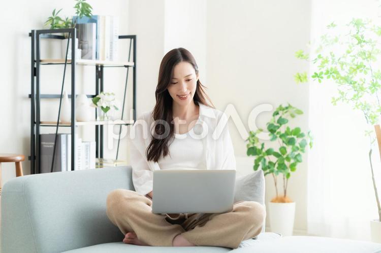リビングでテレワークをする若い女性　　 　　　　　 女性,パソコン,テレワークの写真素材