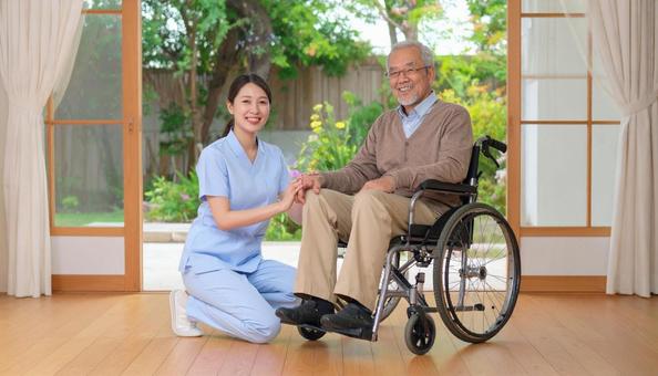 車椅子に乗った高齢男性と女性介護士 車椅子に乗った高齢男性と女性介護士の写真