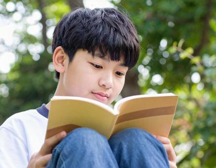 公園で本を読む少年 公園で本を読む少年の写真