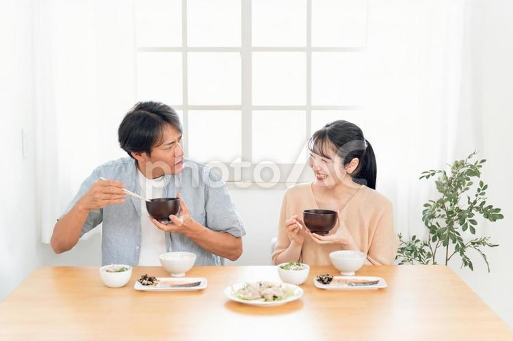 食事しながら怒る男性と笑う女性 夫婦喧嘩,食事,爆笑の写真素材
