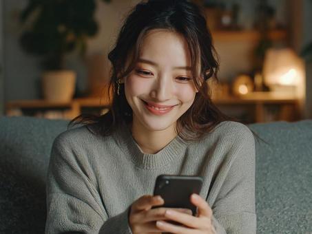 笑顔でスマホを操作する女性 笑顔でスマホを操作する女性の写真