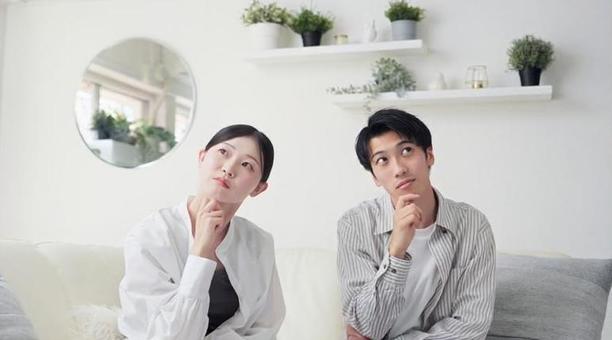 リビングで考え事をするアジア人カップル リビングで考え事をするアジア人カップル 考える,リビング,女性の写真素材