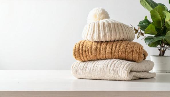 たたまれた冬物の服 たたまれた冬物の服の写真