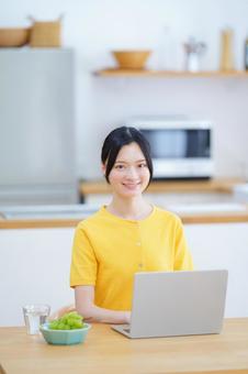 笑顔のパソコン作業中の女性 女性,ノートパソコン,座るの写真素材