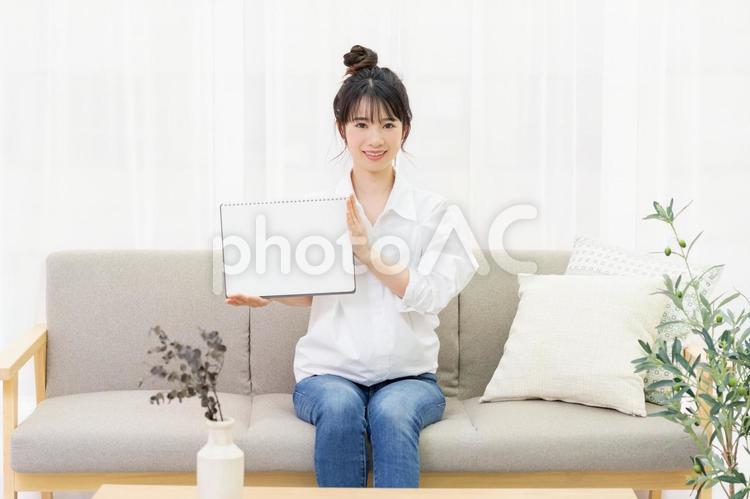 ソファに座って小さいスケッチブックを持つ若い女性 女性,ソファ,家の写真素材
