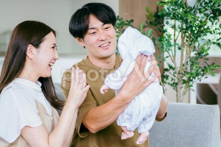 ソファで赤ちゃんを抱く男女 赤ちゃん,育児,新婚の写真素材