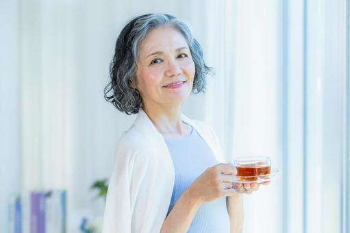 リビングでくつろぐシニア女性 リビングでくつろぐシニア女性の写真