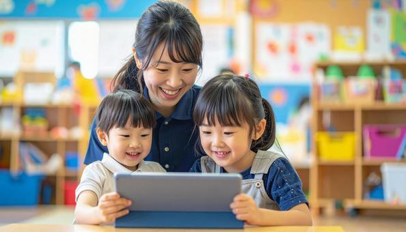 タブレットで遊ぶ保育士と子ども タブレットで遊ぶ保育士と子どもの写真