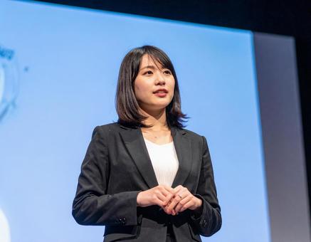 スクリーンの前でプレゼンする女性 スクリーンの前でプレゼンする女性の写真