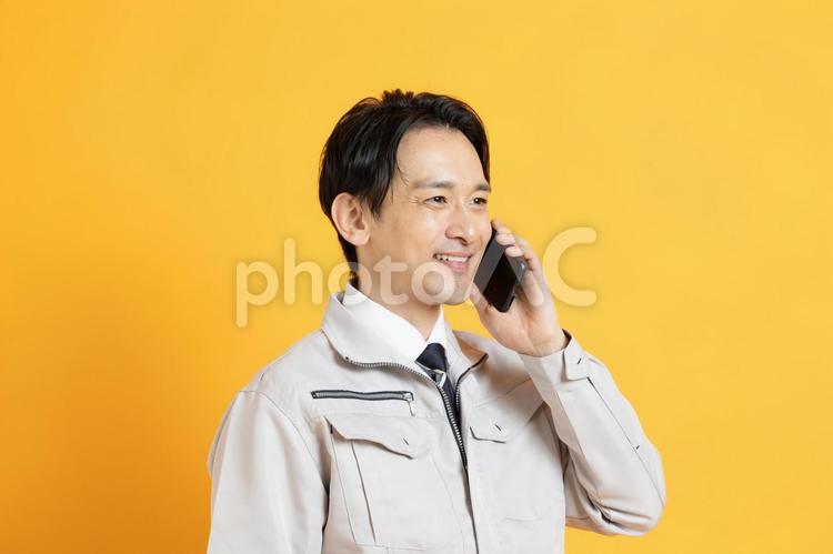 笑顔で電話をかける男性作業員 イケメン,ハンサム,プロフィール写真の写真素材