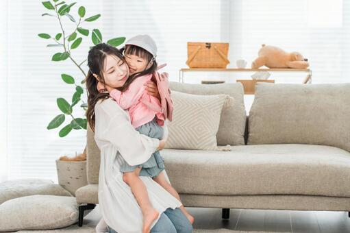 リビングで娘と抱き合う親子,スキンシップ 女の子,抱っこ,ママの写真素材
