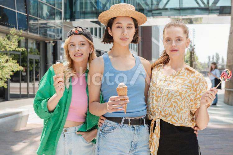 アイスクリームとキャンディーを持ってカメラ目線の女性2 女性,友達,仲間の写真素材