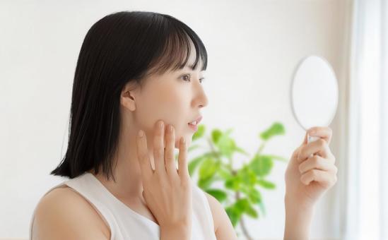 鏡で肌をチェックする女性 女性,美容,健康の写真素材